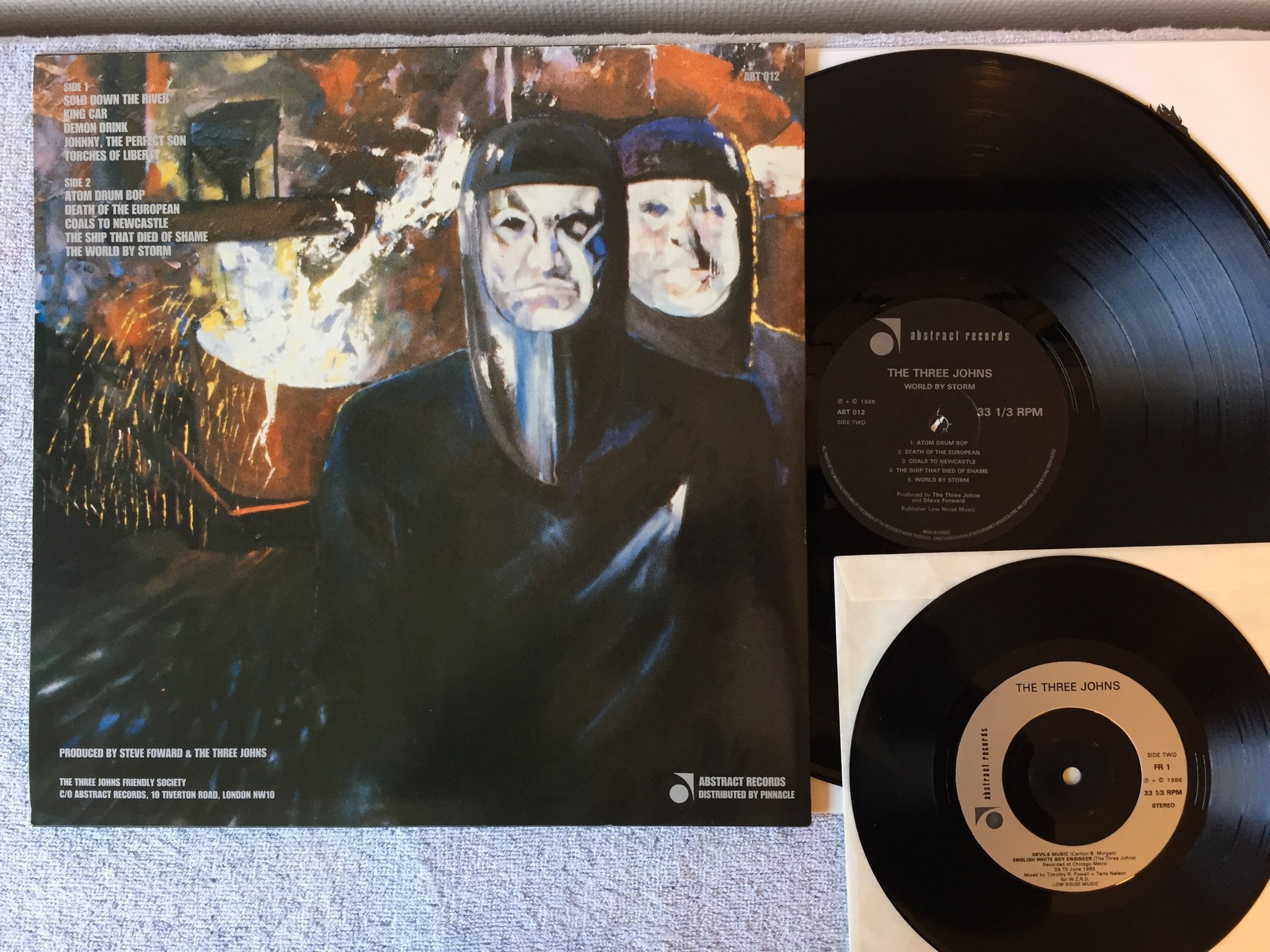 Omslagsbild för skivan THE THREE JOHNS world by storm LP -86 UK ABSTRACT ABT 012