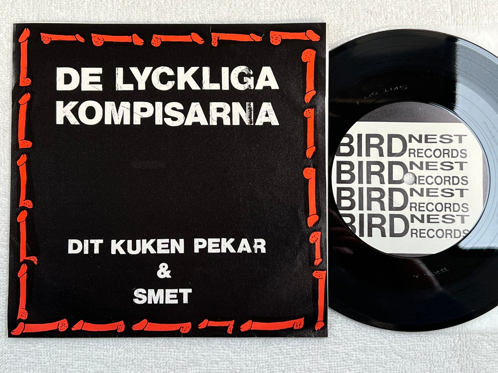 Omslagsbild för skivan DE LYCKLIGA KOMPISARNA dit kuken pekar 7"single -90 BIRD NEST 0221-18597