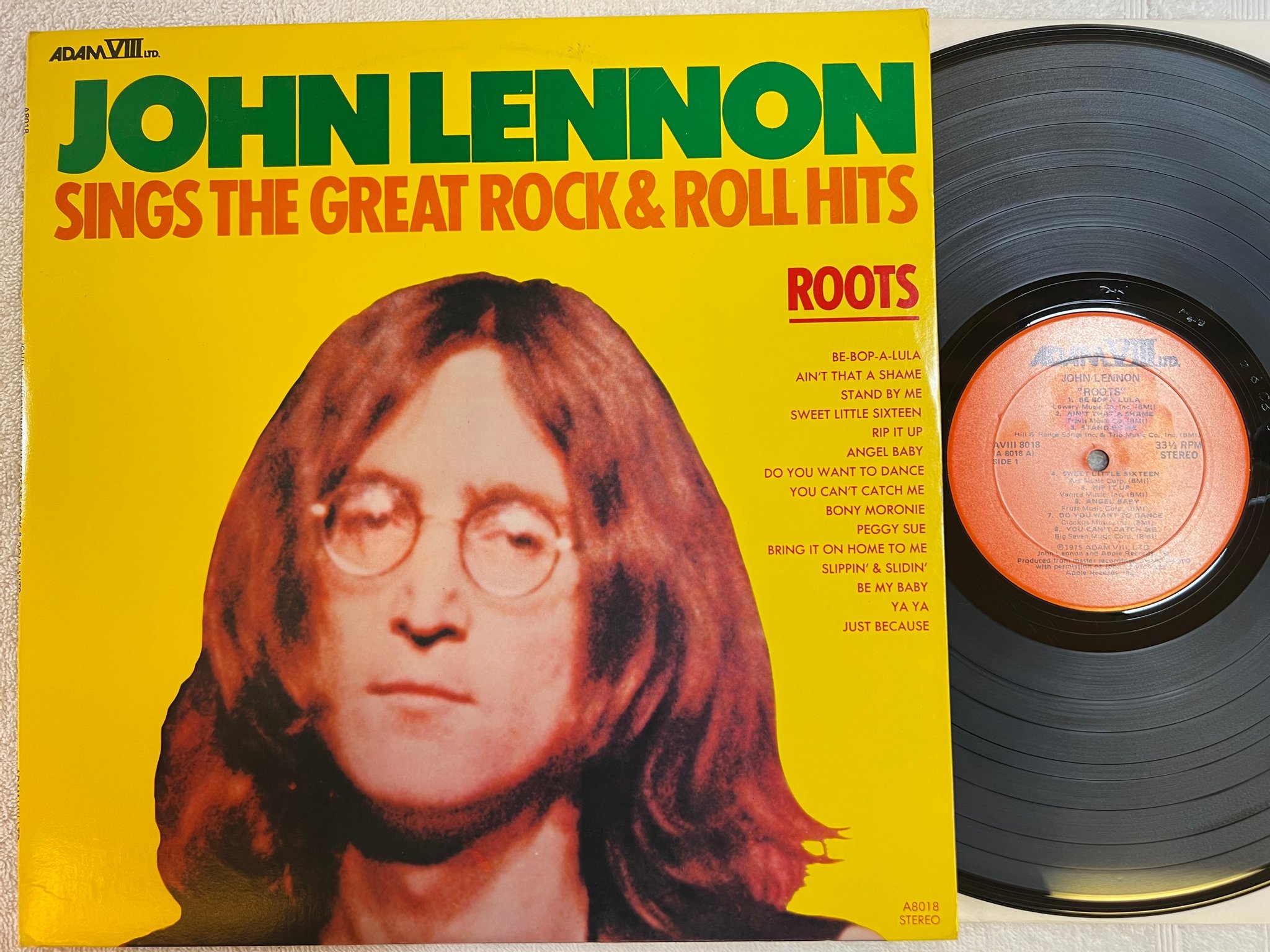Omslagsbild för skivan JOHN LENNON Roots : Sings The Great Rock & Roll Hits LP re US ADAM VIII A8018