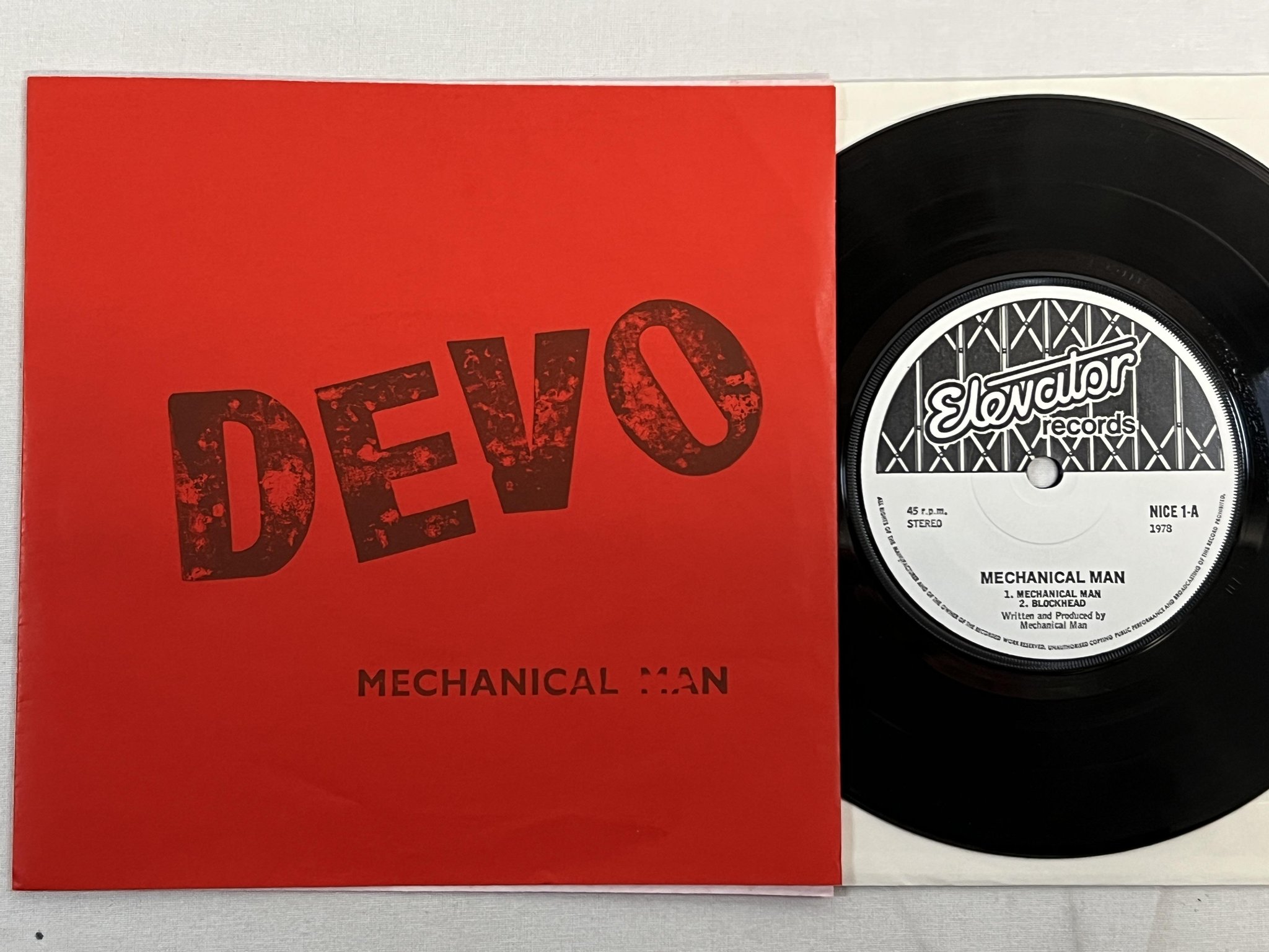 Omslagsbild för skivan DEVO mechanical man 7" -78 UK ELEVATOR NICE 1 electronic ** RED COVER **