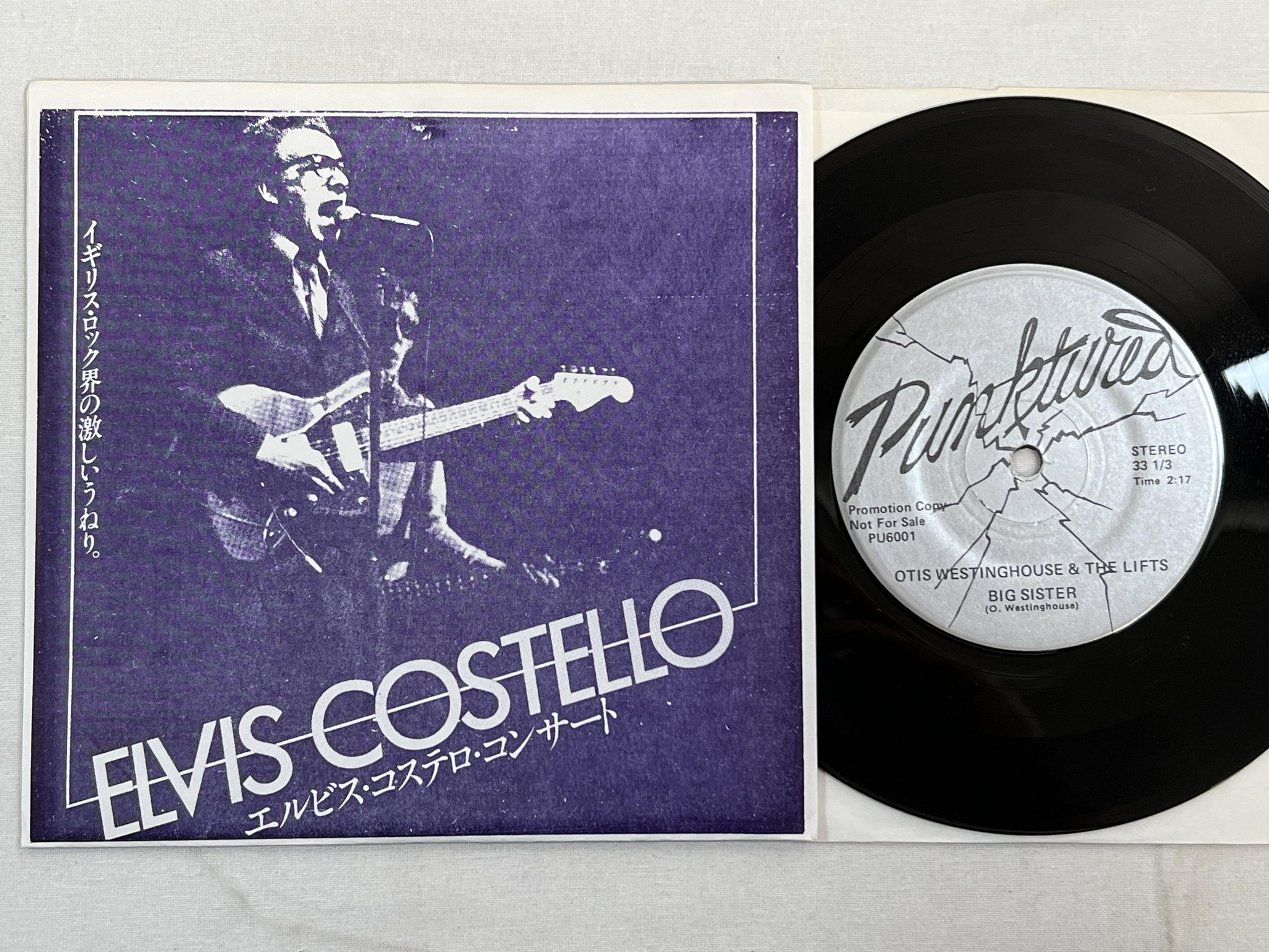 Omslagsbild för skivan ELVIS COSTELLO Big Sister 7" -83 punktured PU6001 promo
