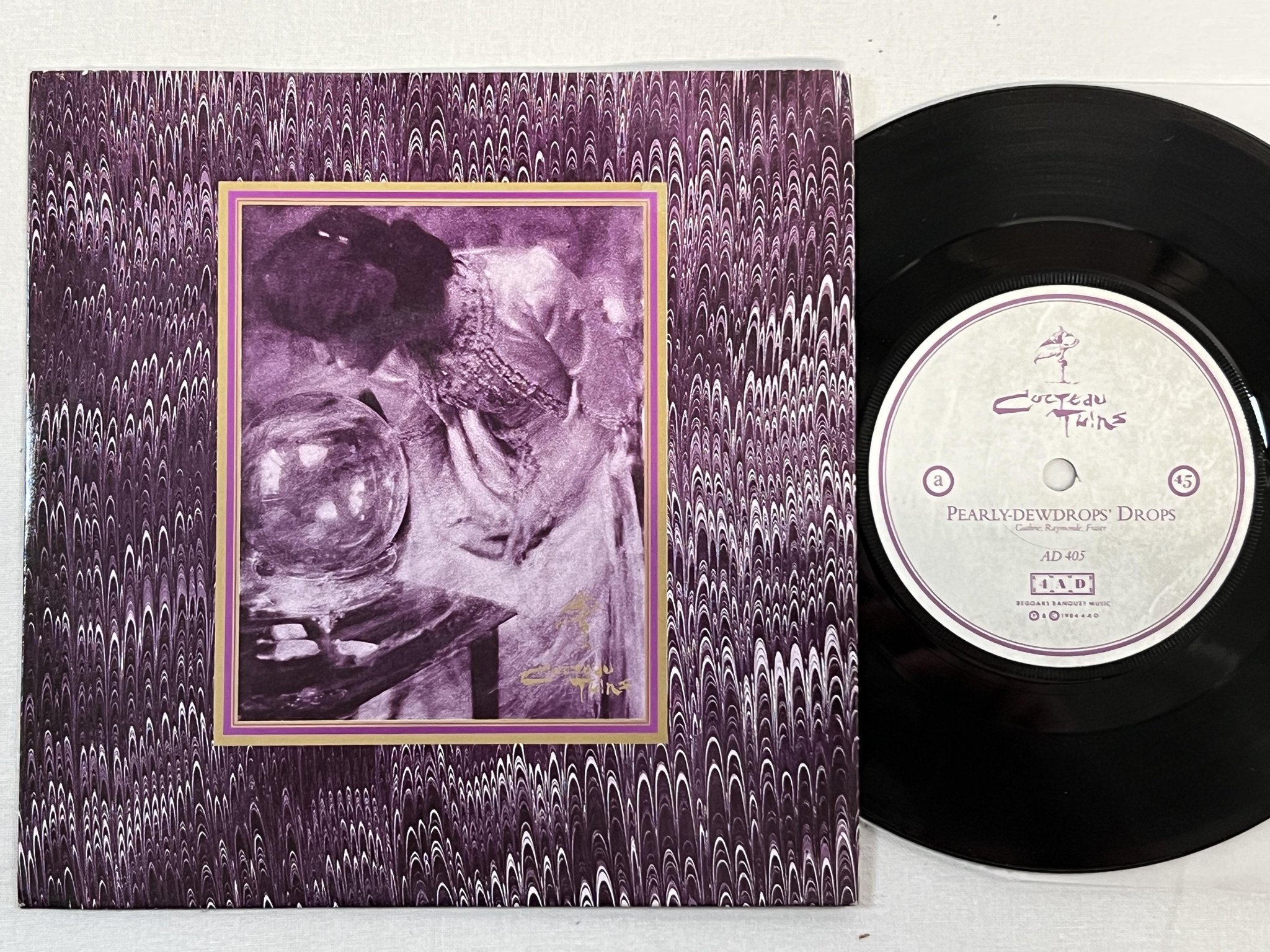 Omslagsbild för skivan COCTEAU TWINS Pearly-Dewdrops' Drops 7" -85 UK 4AD AD 405