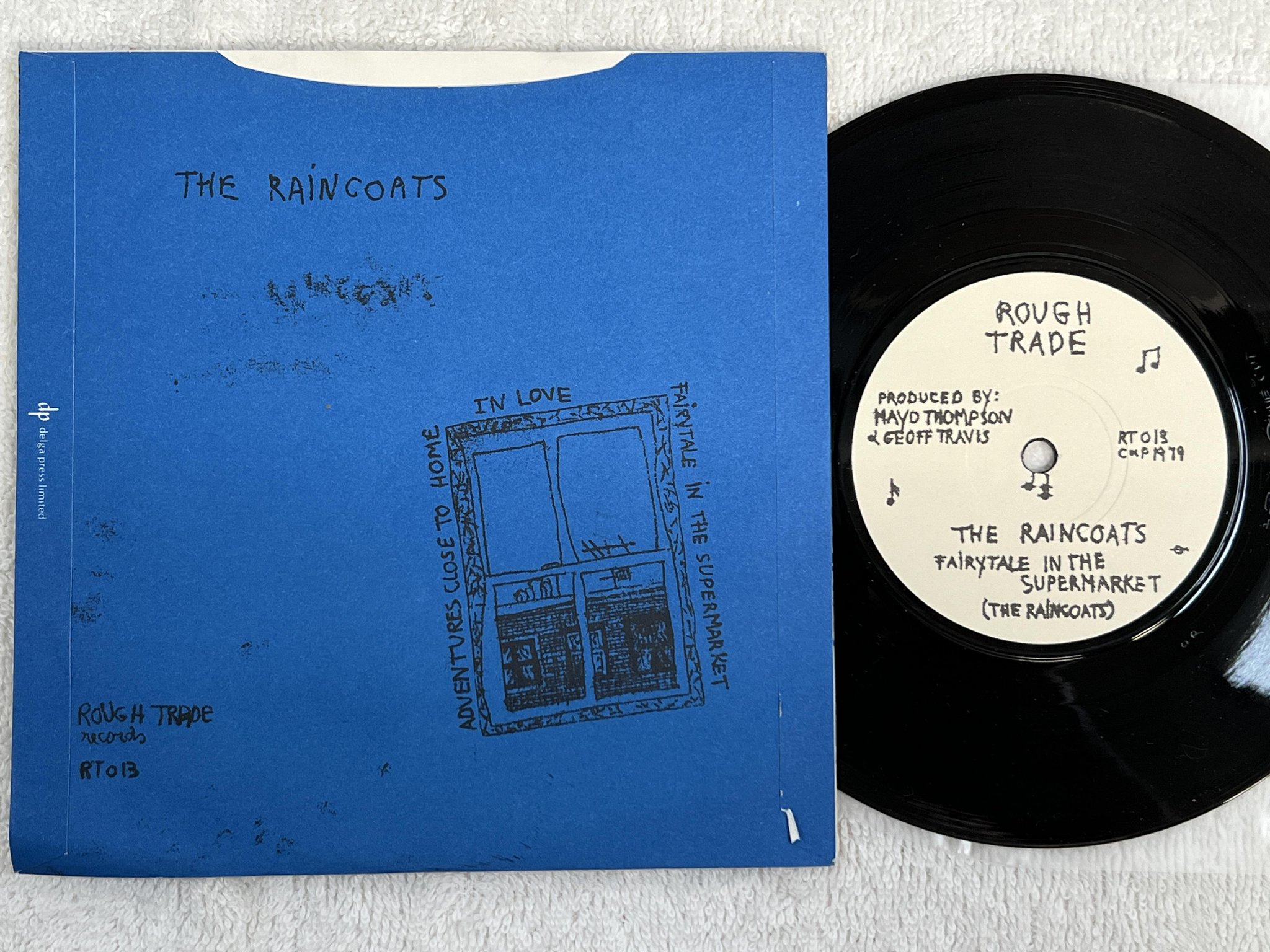 Omslagsbild för skivan THE RAINCOATS Fairytale In The Supermarket 7" -79 UK ROUGH TRADE RT 013