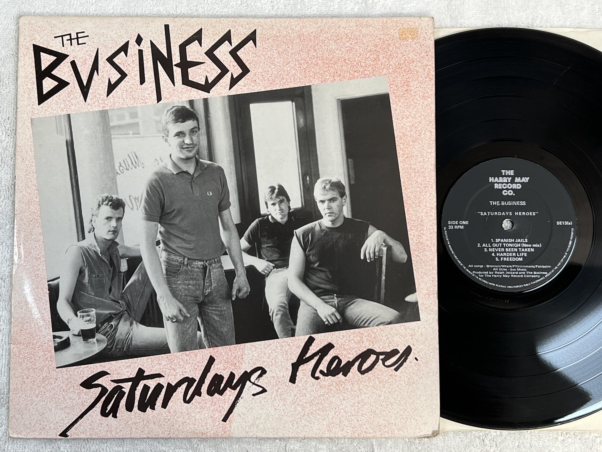 Omslagsbild för skivan THE BUSINESS Saturdays heroes LP -85 UK HARRY MAY SE-13 *** P U N K ***