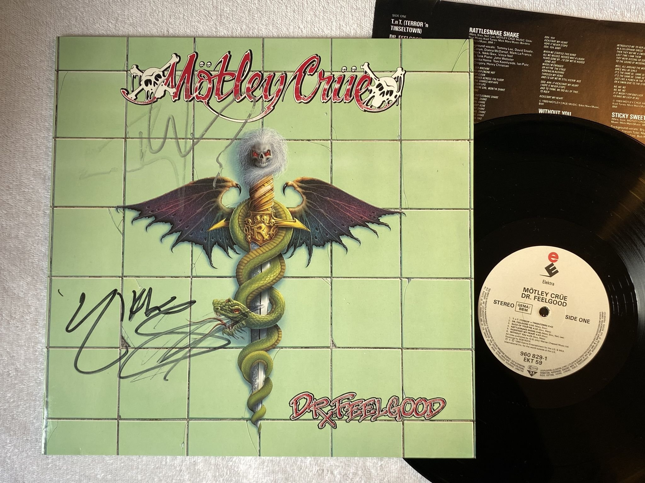 Omslagsbild för skivan MÖTLEY CRÜE Dr Feelgood LP -89 ELEKTRA 960 829-1 *** SIGNED BY TOMMY + NIKKI ***