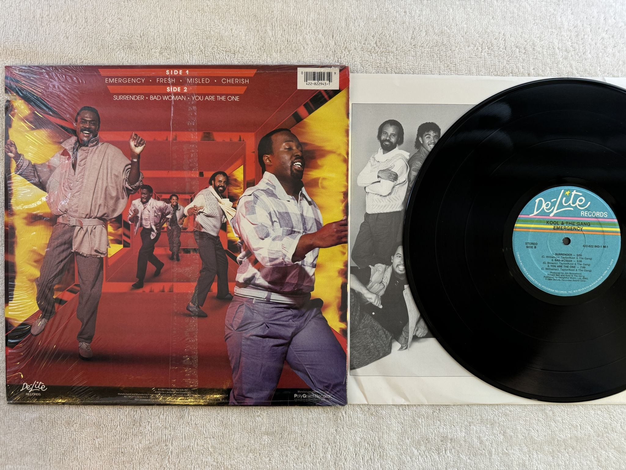 Omslagsbild för skivan KOOL AND THE GANG emergency LP -84 US DE-LITE 422-822 943-1 ** hype sticker **
