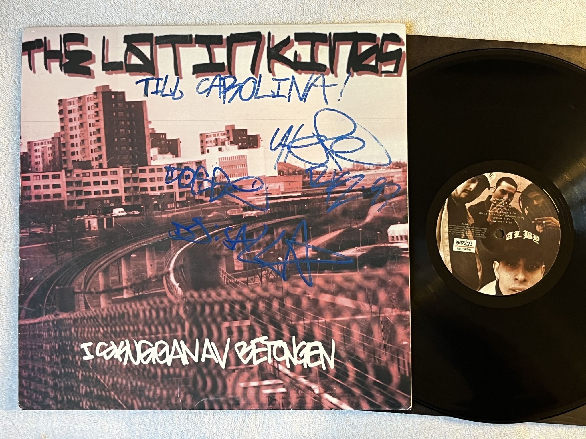 Omslagsbild för skivan THE LATIN KINGS i skuggan av betongen LP -97 Swe REDLINE *** SIGNED BY ALL 3 ***