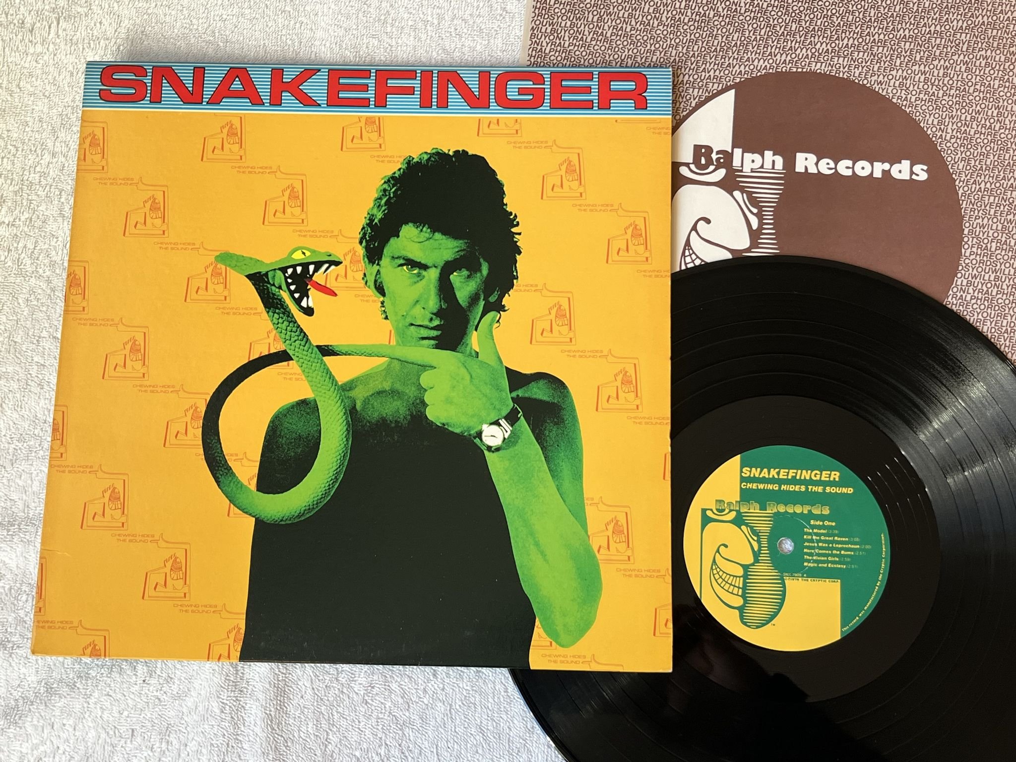 Omslagsbild för skivan SNAKEFINGER Chewing Hides The Sound LP -79 US RALPH SNK 7909