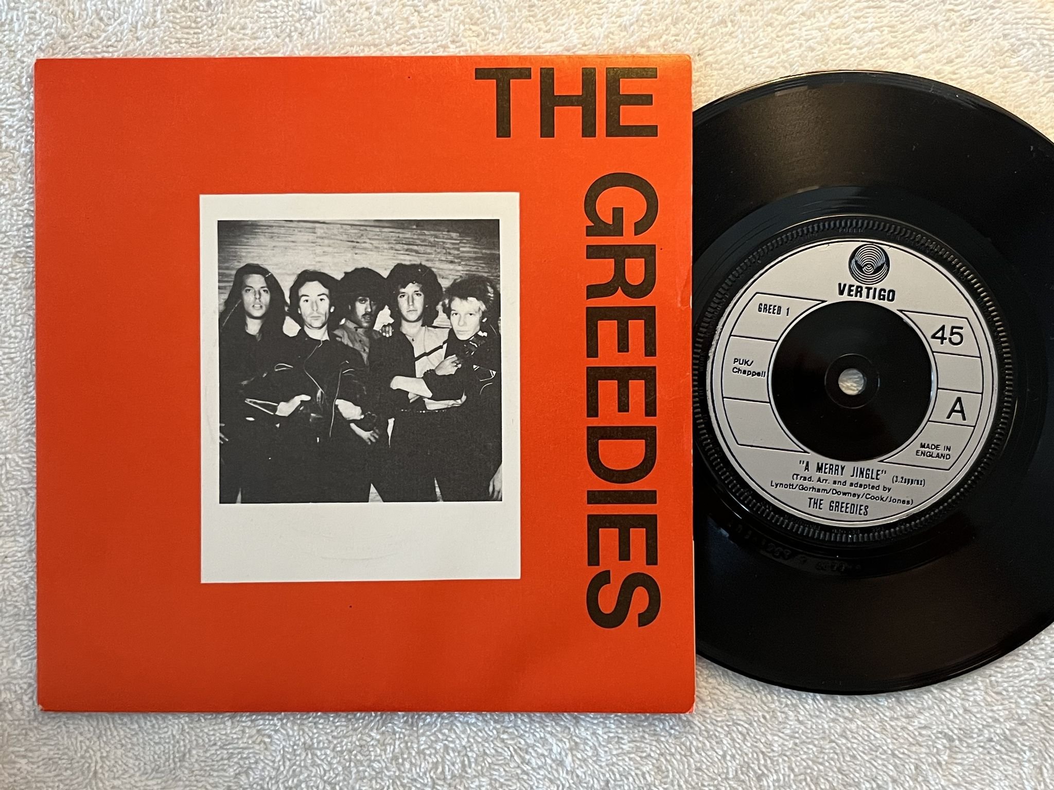 Omslagsbild för skivan THE GREEDIES a merry jingle 7" -79 UK VERTIGO GREED 1