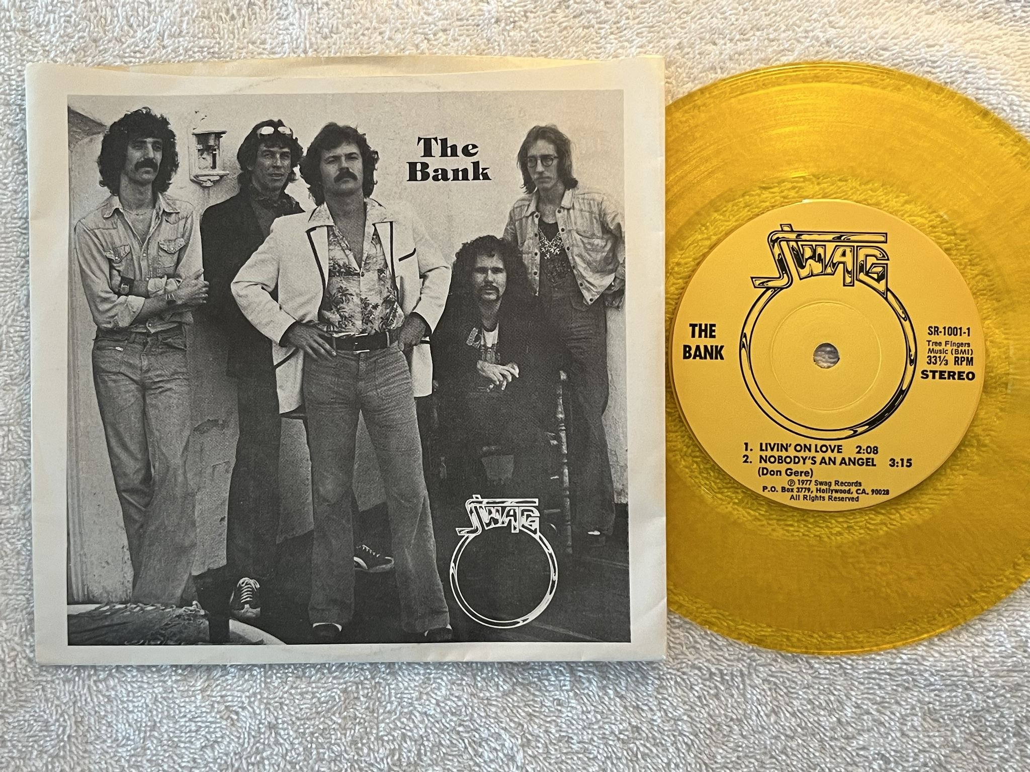 Omslagsbild för skivan THE BANK Alive In Hollywood Hills 7" -77 US SWAG SR-1001 ** INDIE ROCK **